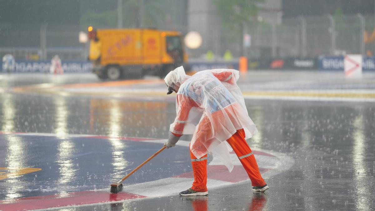 Los comisarios de pista tratan de evacuar el agua en el circuito de Marina Bay.