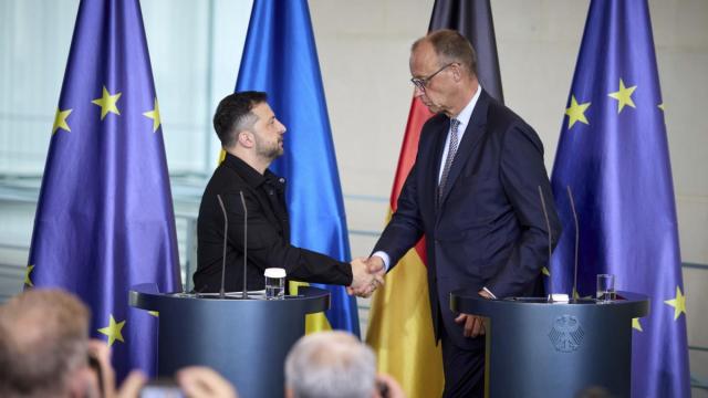 El presidente de Ucrania, Volodimir Zelenski, estrecha la mano del canciller alemán, Friedrich Merz.