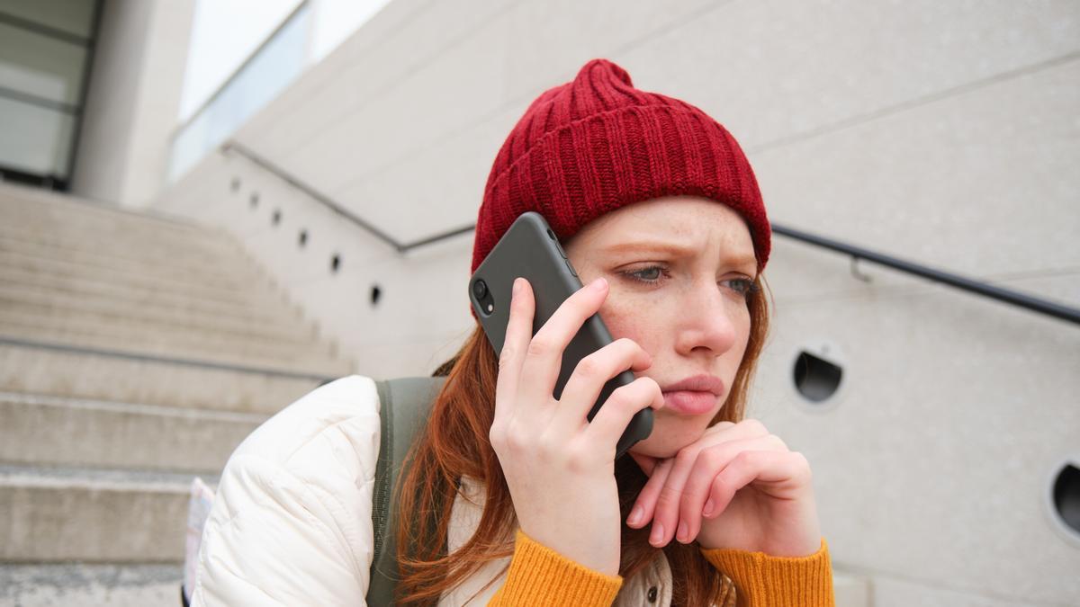 Una joven recibe una llamada spam en su teléfono móvil.