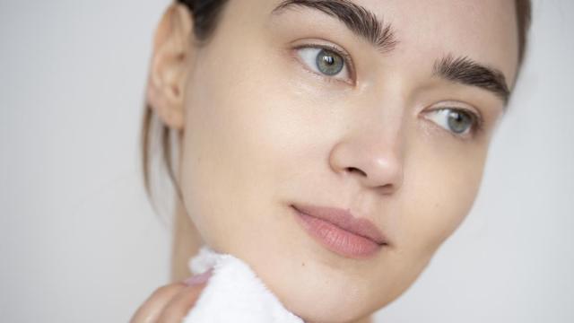 Primer plano del rostro de una mujer con la piel limpia y sin maquillaje.