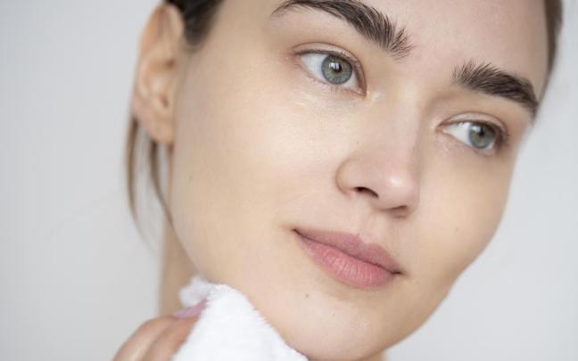Primer plano del rostro de una mujer con la piel limpia y sin maquillaje.