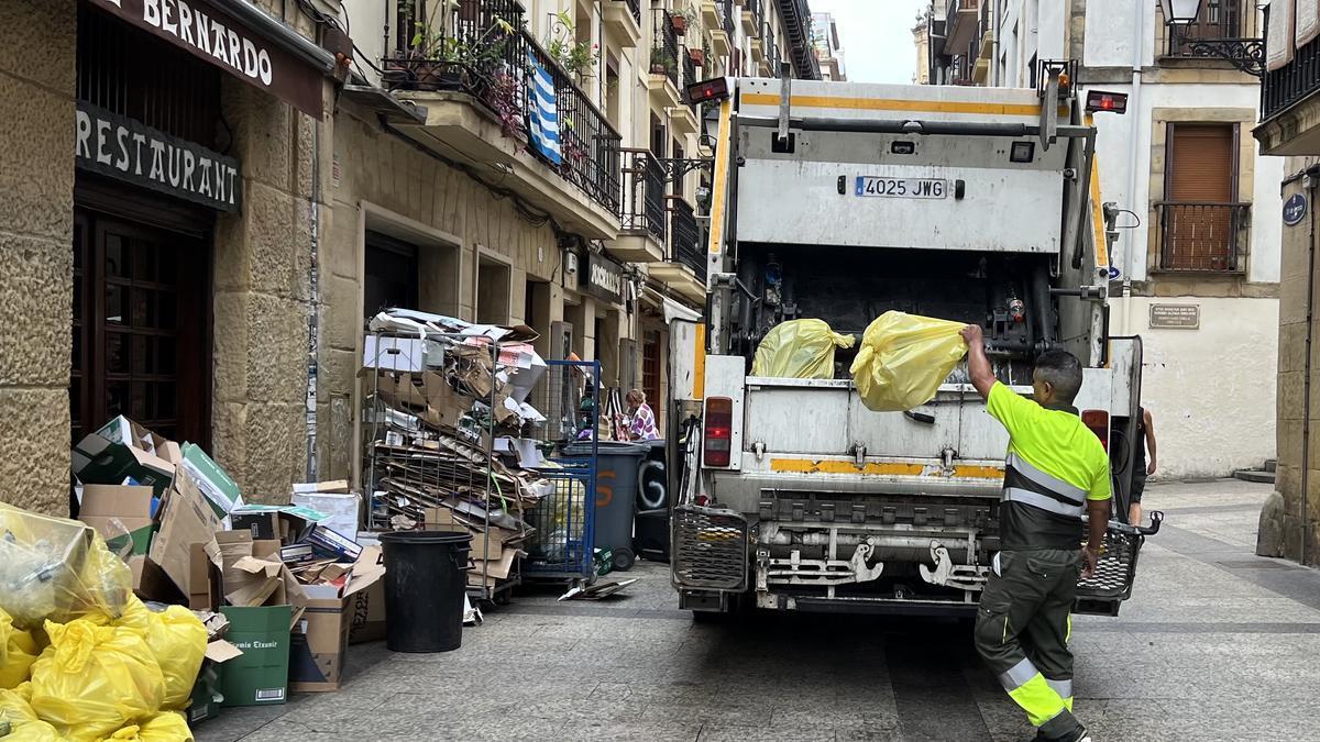Un trabajador recoge bolsas de residuos en la Parte Vieja durante la Aste Nagusia