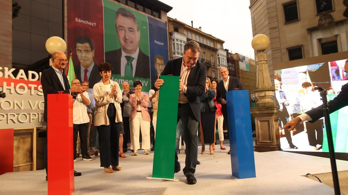 Aitor Esteban, candidato del PNV por Bizkaia, colocando el pulsador verde en el mitin de inicio de campaña del jueves