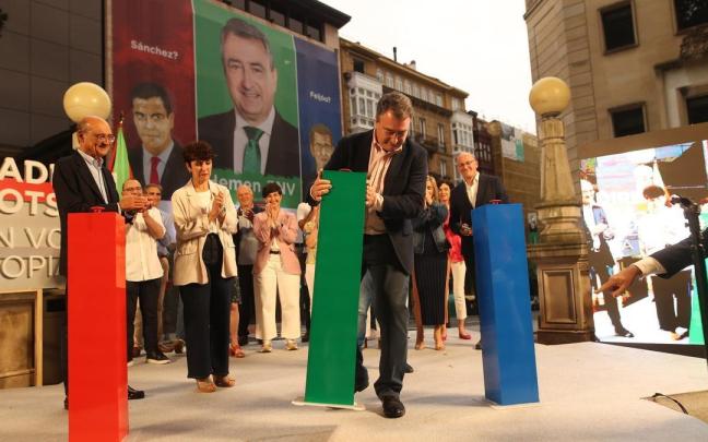 Aitor Esteban, candidato del PNV por Bizkaia, colocando el pulsador verde en el mitin de inicio de campaña del jueves