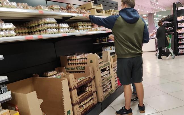 Un joven compra huevos en una gran superficie.