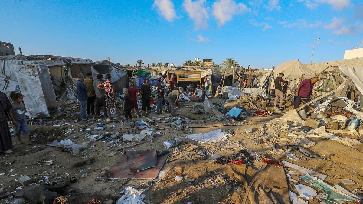 Refugiados palestinos inspeccionan los destrozos causados por un ataque israelí en Deir Al Balah, en el centro de Gaza.