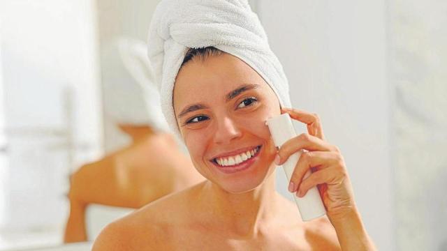 Una chica se aplica crema solar en el rostro.