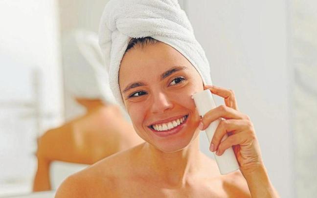Una chica se aplica crema solar en el rostro.