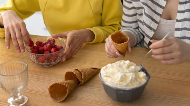 Dos personas preparan la merienda en casa.