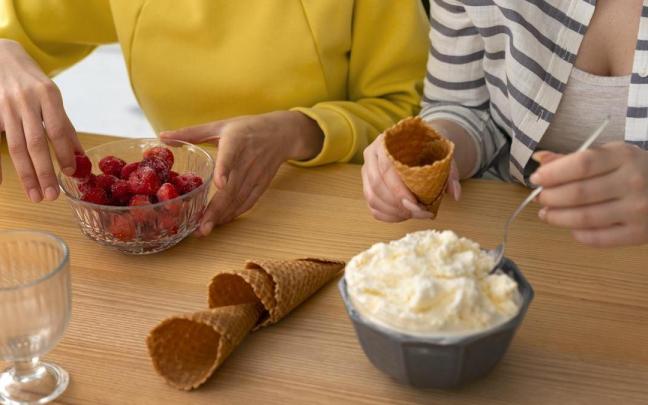 Dos personas preparan la merienda en casa.