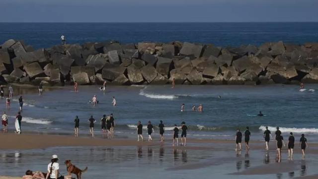 Bañistas y paseantes disfrutan este miércoles de un día soleado en la playa de la Zurriola de San Sebastián.