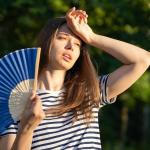 Una mujer se abanica para contrarrestar el malestar por el calor. Una mujer se abanica para contrarrestar el malestar por el calor.