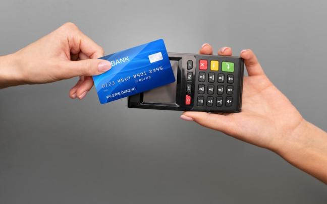 Una persona paga su tarjeta en un datáfono.