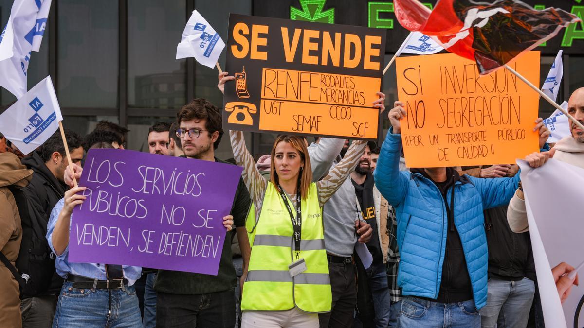 Varios trabajadores de Renfe y Adif con carteles durante una concentración por la huelga estatal, en la Estació de Sants