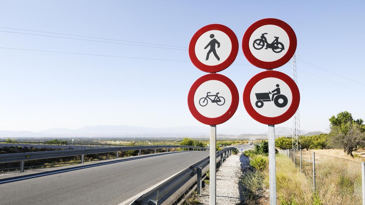 Cuatro señales de tráfico en la carretera.