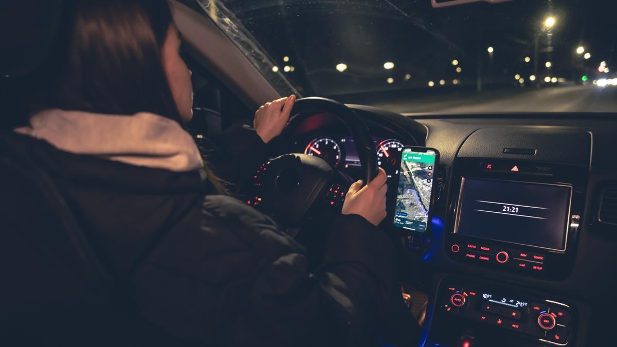 Una mujer, conduciendo por la noche.