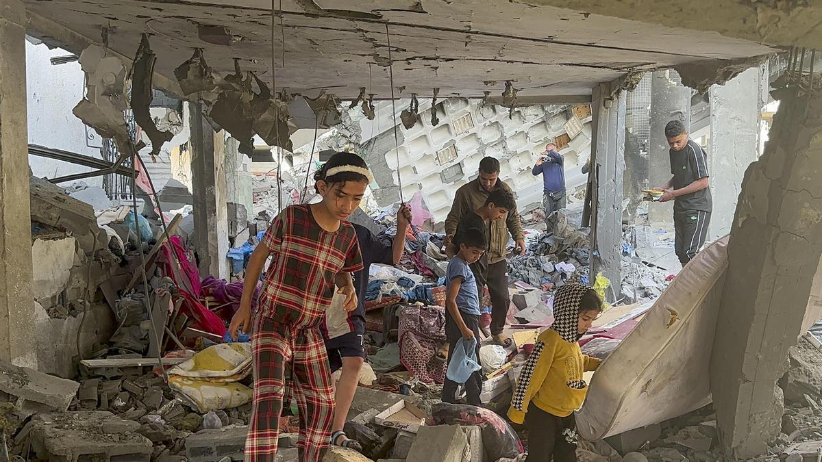 Algunos niños caminan por los escombros tras un ataque israelí en Rafah.