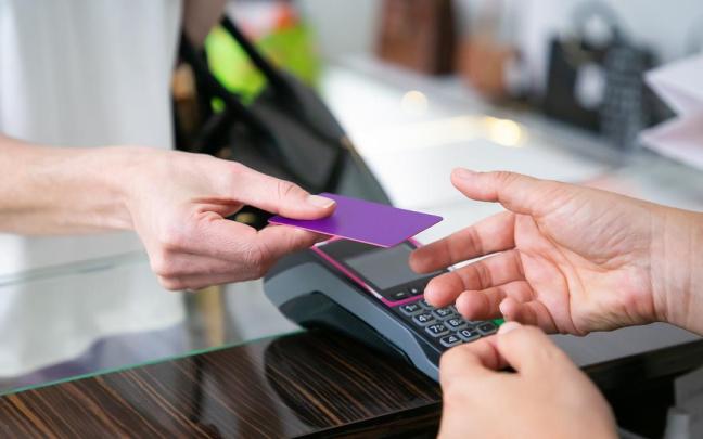 Una persona paga con tarjeta de crédito Una persona paga con tarjeta de crédito
