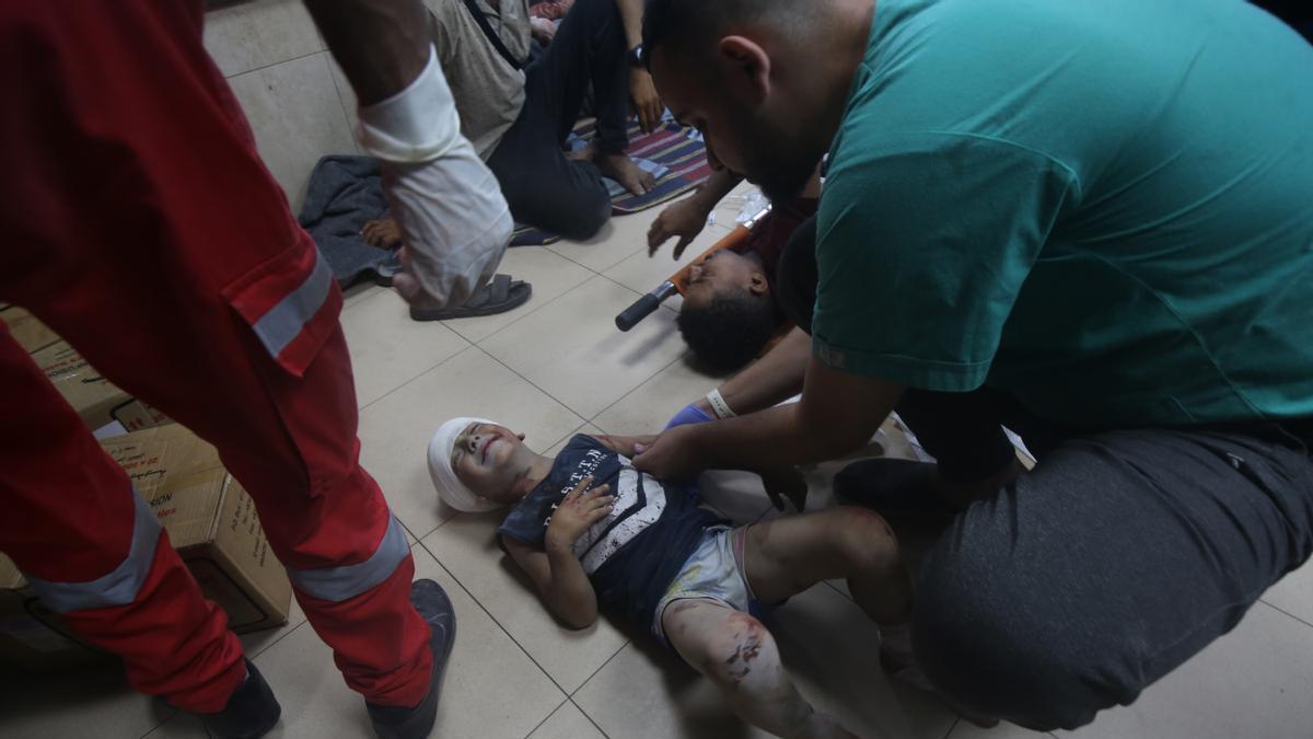 Un niño llora mientras es atendido en el suelo de un hospital de Deir al Balah.