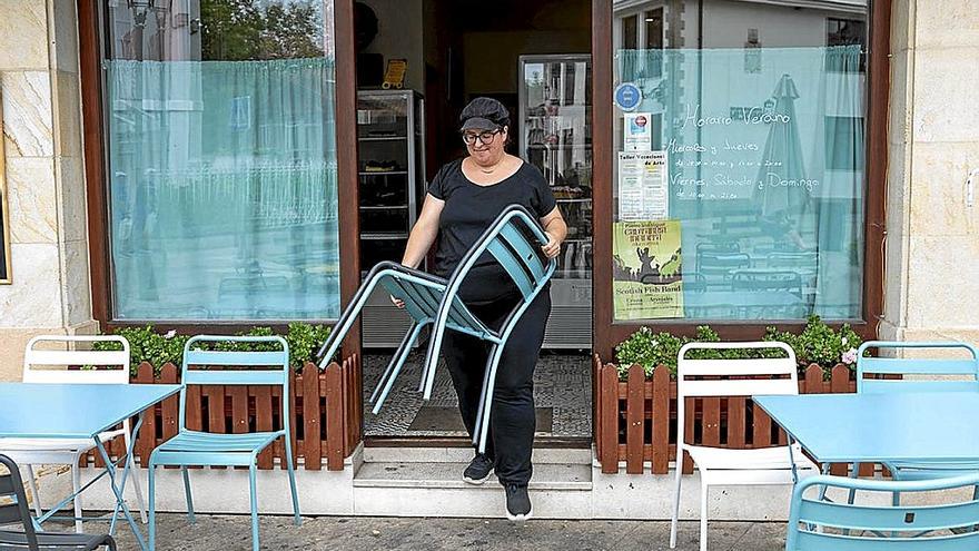 Una mujer prepara una terraza en la localidad cántabra de Puente San Miguel.