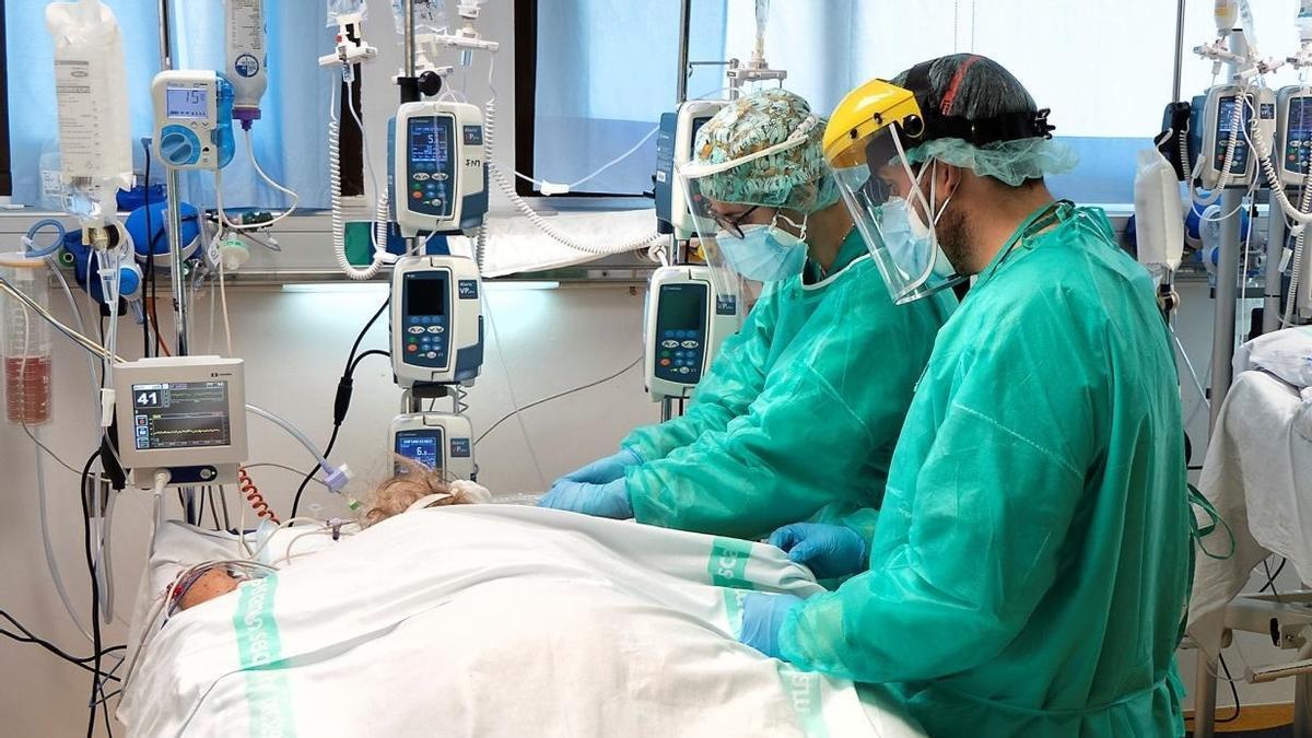Dos trabajadores sanitarios tratando a un paciente de covid en la UCI.