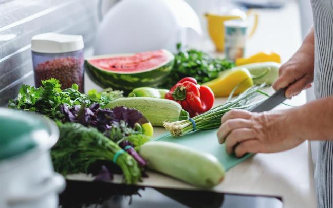 Una mujer cortando verduras. Una mujer cortando verduras.