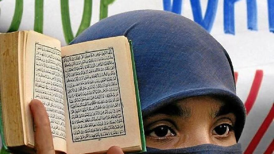 A Paquistani woman shows a Quran, in a file image.