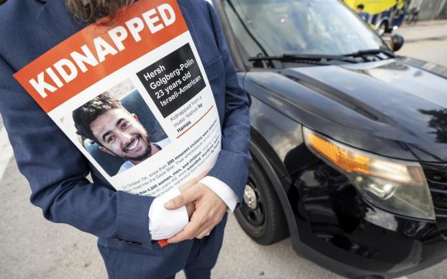 Un hombre sujeta un cartel con la imagen del rehén Hersh Goldberg-Polin.