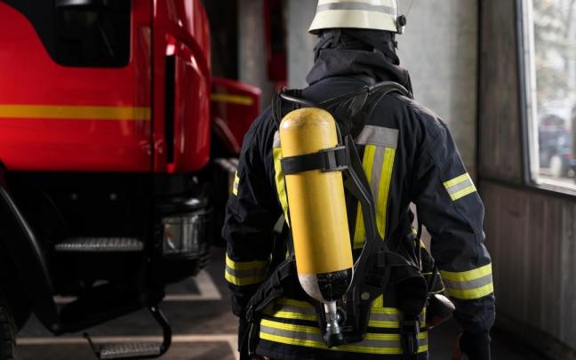 Un bombero preparado junto a un camión. / Freepik Un bombero preparado junto a un camión.