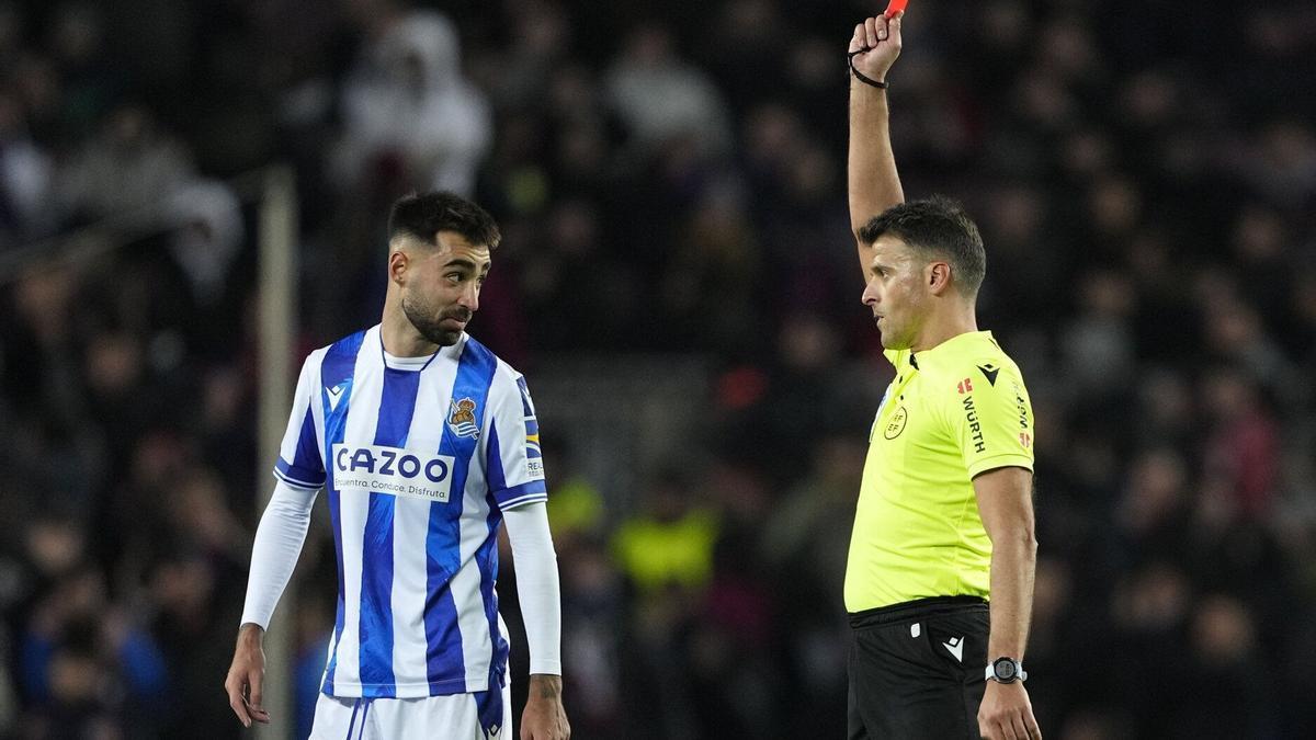 El árbitro Gil Manzano muestra la tarjeta roja a Brais Méndez, centrocampista de la Real Sociedad, durante el encuentro de cuartos de final de Copa del Rey entre el FC Barcelona y la Real Sociedad, este miércoles en el estadio Spotify Camp Nou, en Barcelona. / EFE/ ALEJANDRO GARCÍA