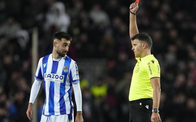 El árbitro Gil Manzano muestra la tarjeta roja a Brais Méndez, centrocampista de la Real Sociedad, durante el encuentro de cuartos de final de Copa del Rey entre el FC Barcelona y la Real Sociedad, este miércoles en el estadio Spotify Camp Nou, en Barcelona. / EFE/ ALEJANDRO GARCÍA