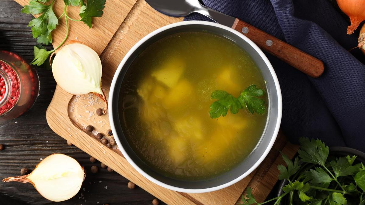 Un puchero con caldo de pollo y verdura.