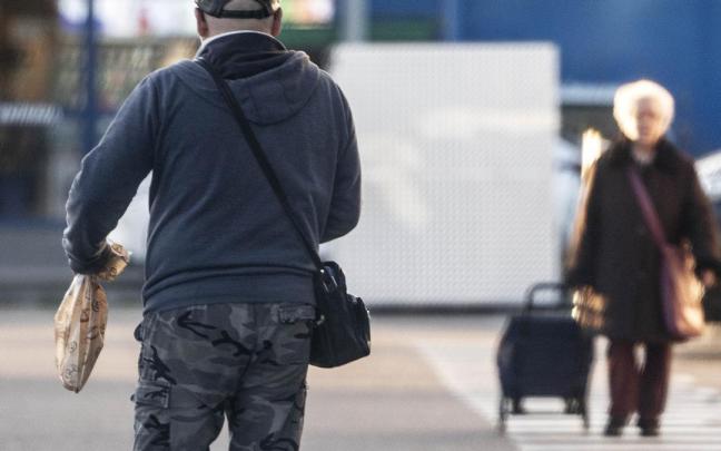 Un hombre sale de un supermercado.