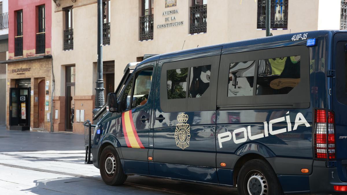 Un furgón de la Policía Nacional circula por la Avenida de la Constitución de Sevilla.