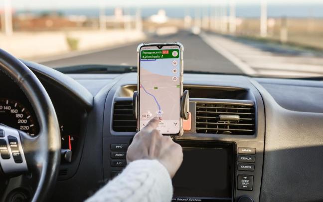 Un conductor manipula el navegador en su teléfono móvil.
