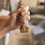 Una mujer sostiene en su mano las llaves de su nueva vivienda.