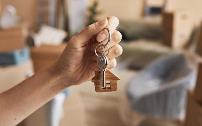 Una mujer sostiene en su mano las llaves de su nueva vivienda.