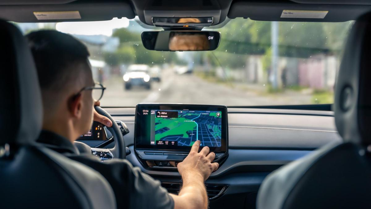 Un hombre toca la pantalla táctil de su coche.