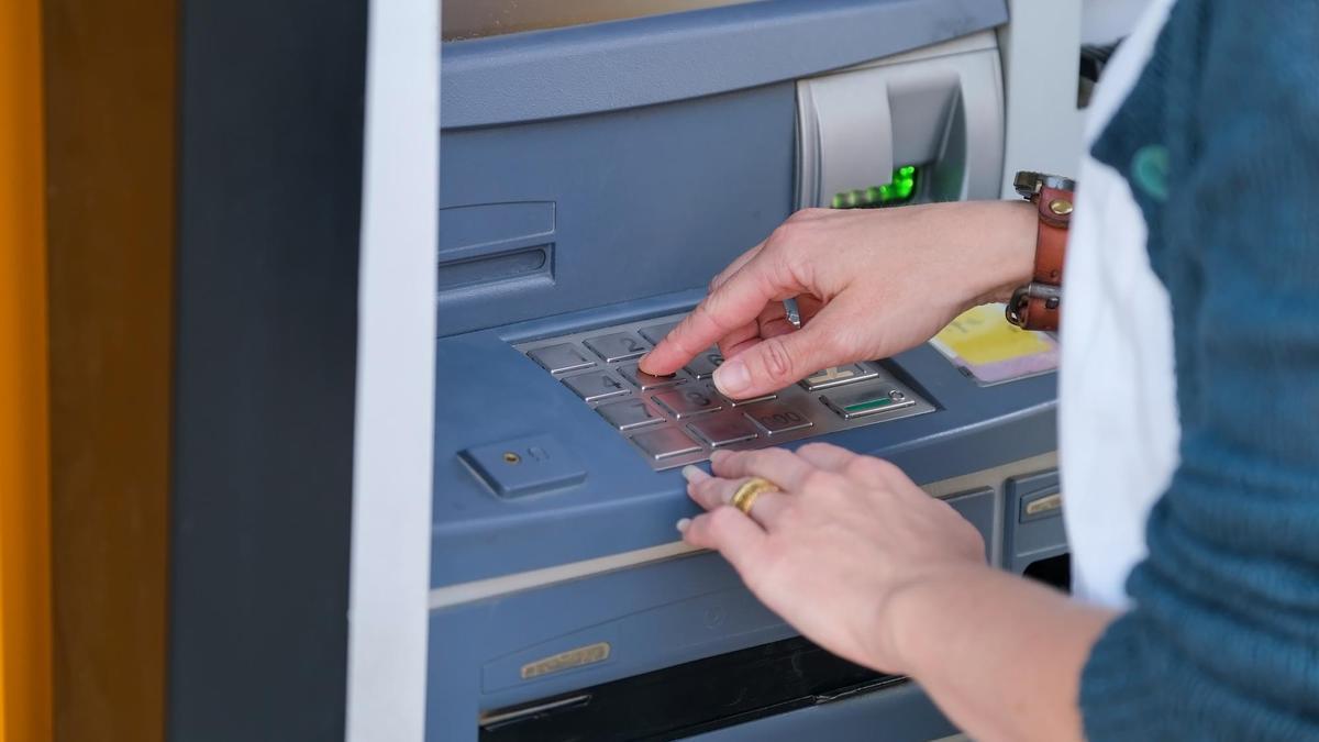 Una mujer realiza una operación en un cajero automático.