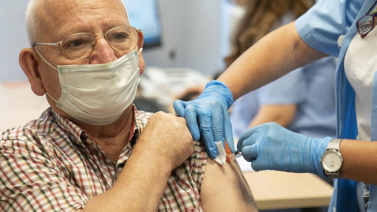 Un hombre recibe una vacuna contra la gripe.