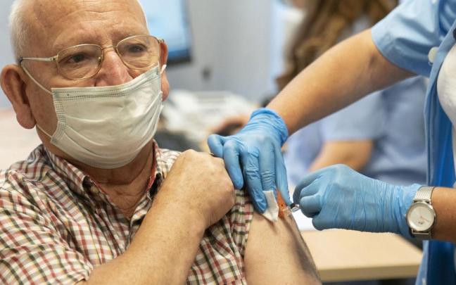 Un hombre recibe una vacuna contra la gripe.