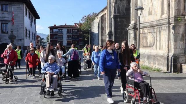 Jóvenes paseando junto a personas mayores.