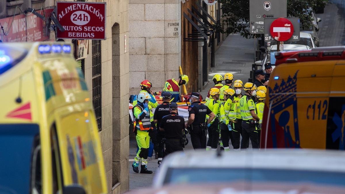 Agentes de Policía Nacional y trabajadores de emergencias en las inmediaciones dónde se ha derrumbado un edificio en obras.