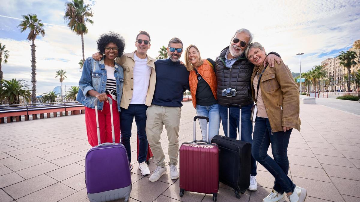 Turistas posan con sus maletas al llegar a su destino.