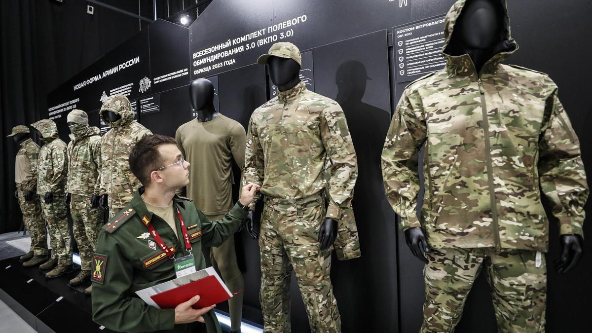 Un soldado examina varios uniformes militares expuestos en la feria Army 2023.