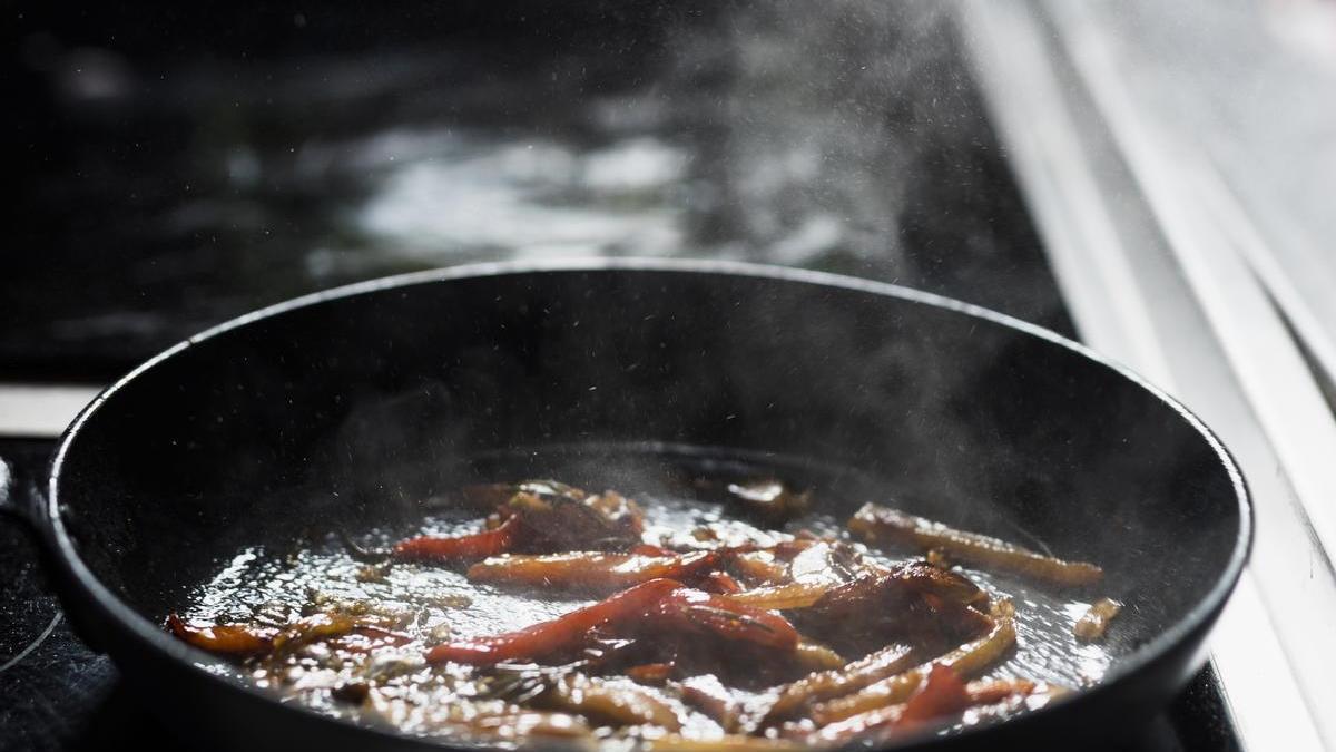 Cacerola con verduras fritas en estufa.