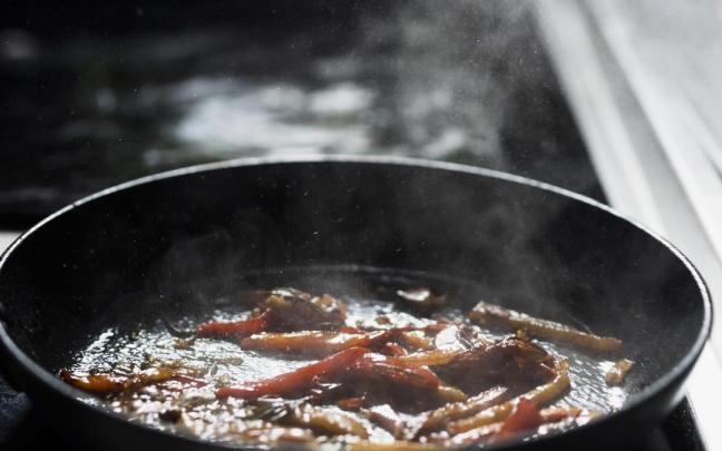 Cacerola con verduras fritas en estufa.