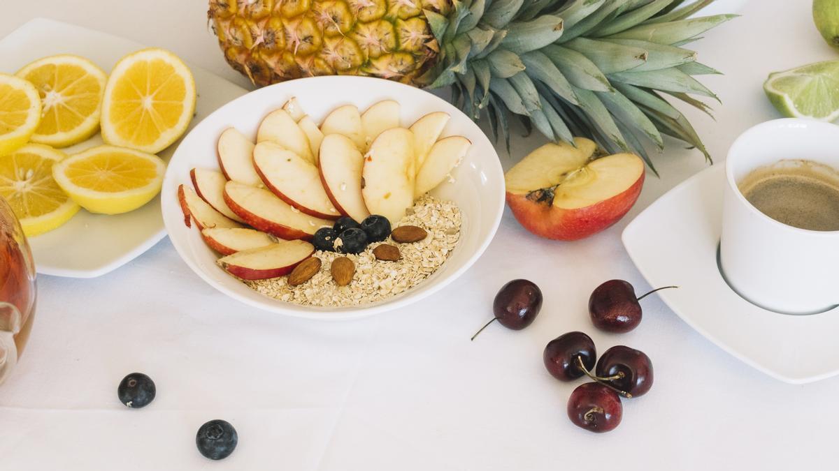 Desayuno con fruta, avena y un café con leche