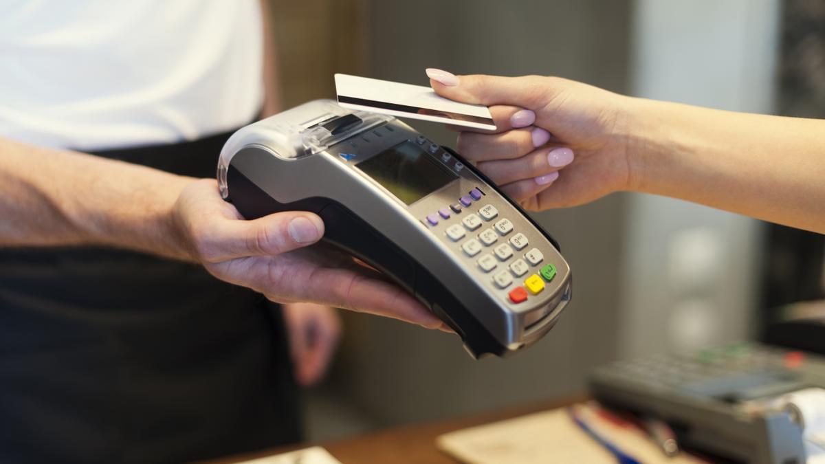 Una persona realiza un pago en un datáfono con su tarjeta.