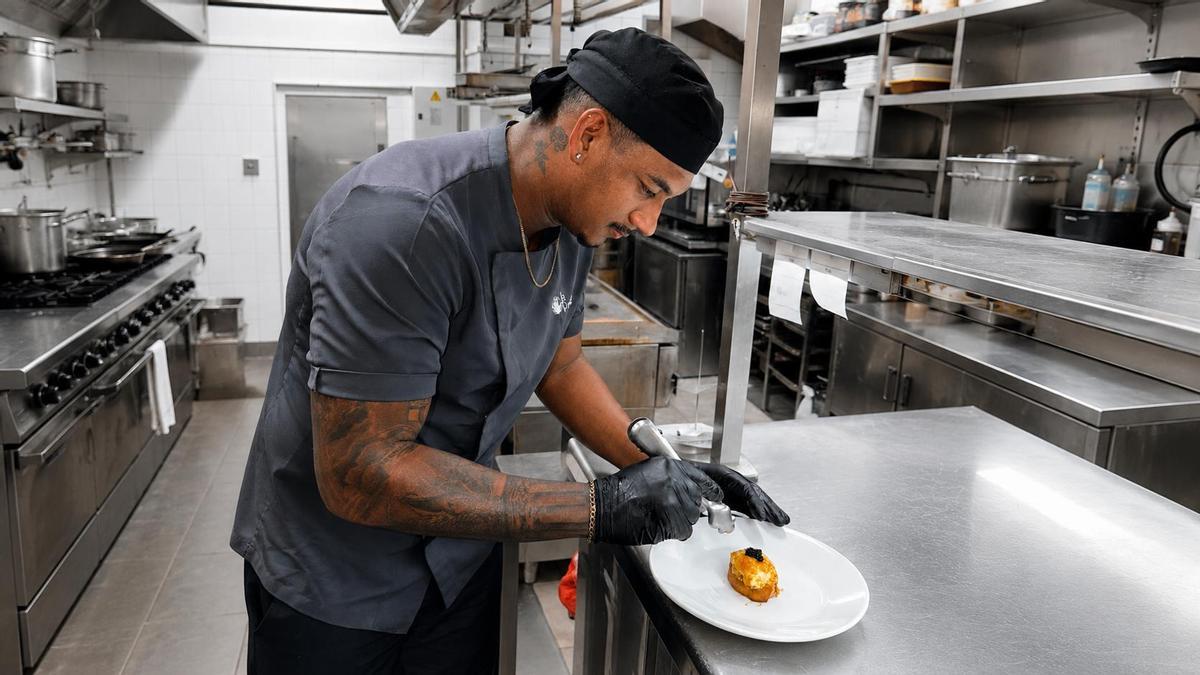 César David Meneses ultima el emplatado de una elaboración en la cocina.